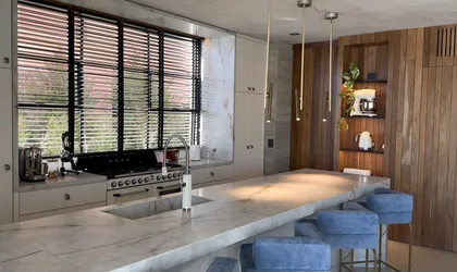 Cocina moderna con isla de mármol y grandes ventanales — proyecto CASA MHN, por Hermann Arquitectos, en Nordelta